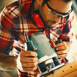 Man using a power tool wearing safety glasses