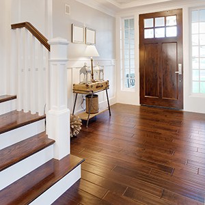 hardwood flooring in an entry way with a craftsman style door and a hardwood staircase