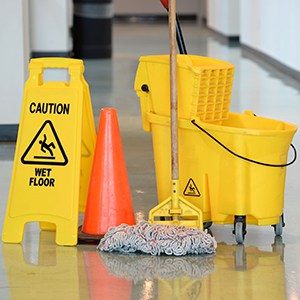 caution sign with mop and bucket on office floor