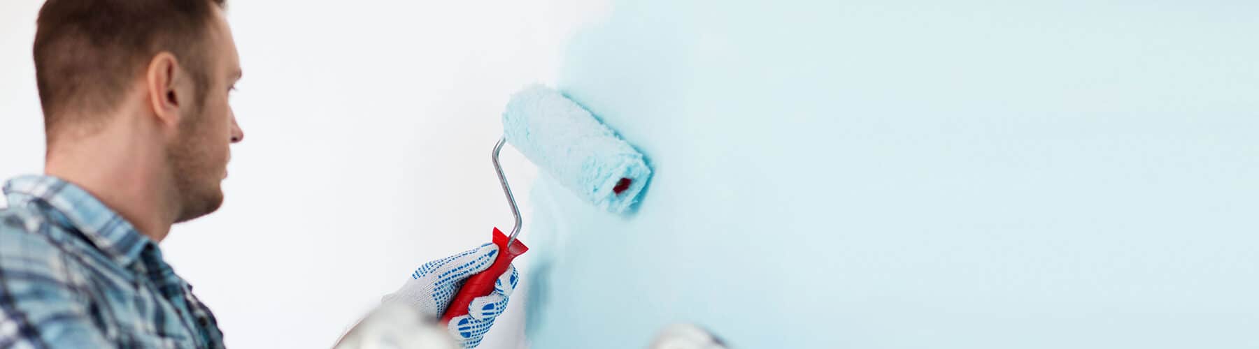 close up of male in gloves holding painting roller