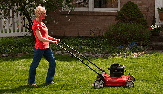 woman in a red shirt and jeans mowing grass