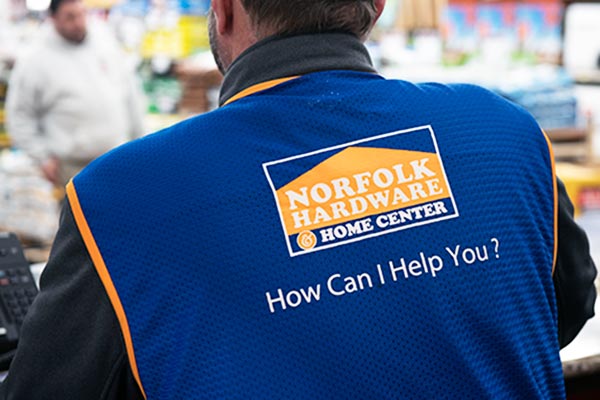 back of Norfolk employee vest, with the Norfolk Hardware logo and the question "How can i help you?"